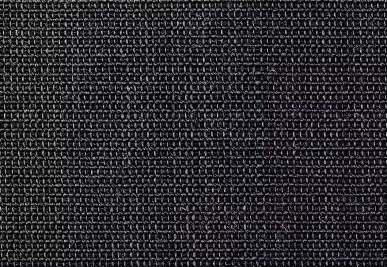 Close-up of a dark, textured fabric with a tightly woven pattern. The fabric appears durable and dense.