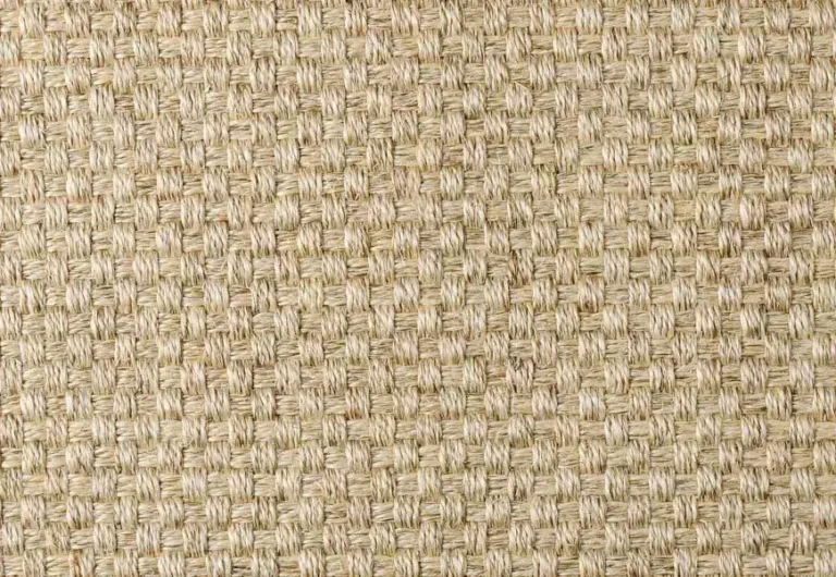 Close-up of a woven beige fabric with a textured, grid-like pattern, possibly made of natural fibers like jute or sisal.