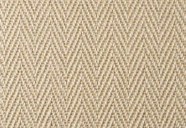 Close-up of a beige herringbone woven fabric texture. The pattern consists of tightly interwoven fibers creating a repeated V-shaped design.