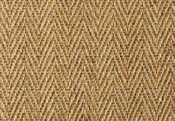 Close-up of a woven fabric with a textured, chevron pattern in natural tan and brown tones.