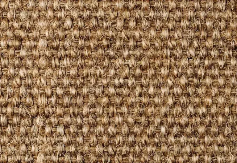 Close-up of a woven jute fabric, showcasing a textured pattern with interlaced natural fibers in a beige-brown color.
