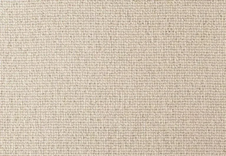 A close-up of a beige, tightly woven fabric with a uniform texture.