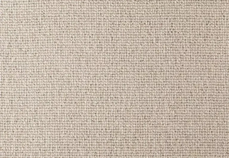 Close-up of a beige textured woven fabric with a grid-like pattern. The material appears to be tightly woven, creating a uniform and consistent surface.