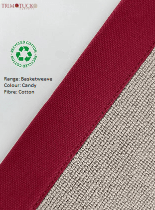 Close-up of fabric sample labeled with the brand TrimTuck. The sample shows two types of fabric: a red woven material and a textured beige fabric with a recycling symbol indicating recycled cotton.