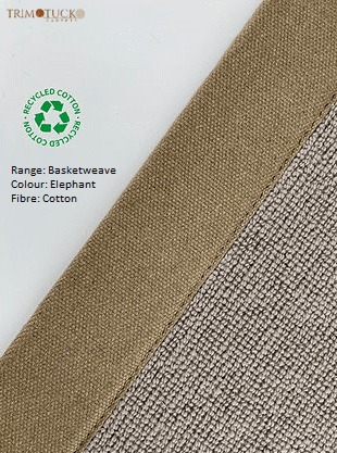 Close-up of a beige basketweave fabric with a label indicating it is made of recycled cotton. The label mentions 
