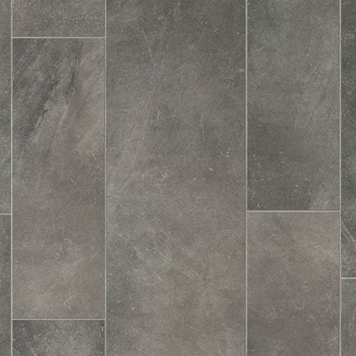 A close-up view of a gray stone tile floor with visible grout lines, showing a pattern of rectangular tiles.