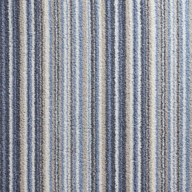A close-up view of a carpet with vertical stripes in shades of blue, gray, and beige.