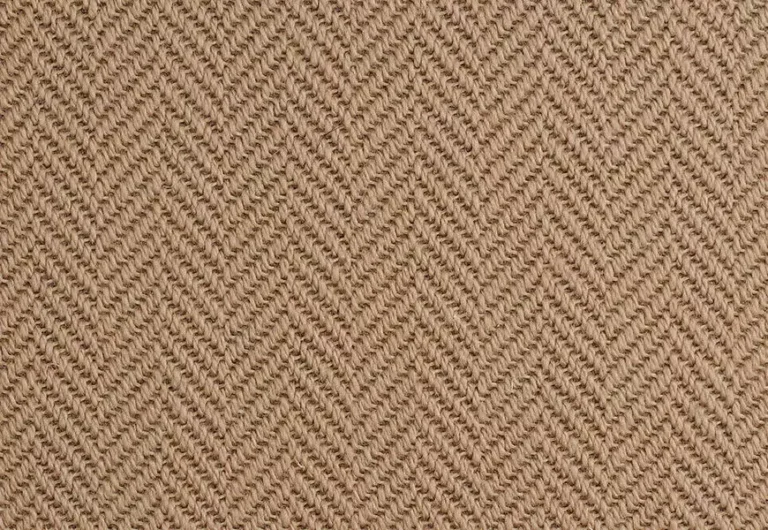 A close-up view of a woven fabric with a herringbone pattern in a beige color.