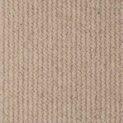 Close-up of a beige, textured carpet with a tightly woven pattern. The surface appears soft and uniform.