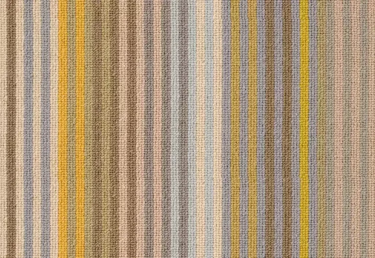 Margo Selby Stripe Sun is a textured fabric with vertical stripes in various colors, including beige, yellow, brown, blue, and gray.