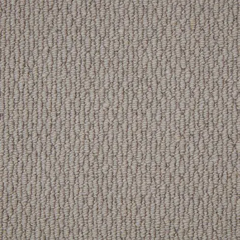 Close-up of a beige loop-pile carpet texture with tightly packed, uniformly arranged loops, creating a consistent, patterned surface.