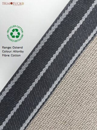 Close-up of upholstery fabric sample from the Oxtend Binding range in Allonby color, featuring cotton fiber and a black trim with white stitching. Includes a recycled cotton symbol.