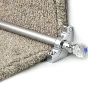 A carpet rod with a crystal finial secures a stair carpet runner in place.