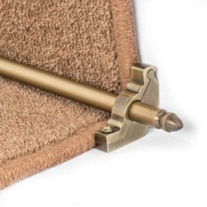 Close-up of Stair Rods - Homepride with decorative brackets holding down the edge of a brown carpet on a staircase.