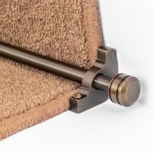 Close-up of a metal bracket securing the edge of a carpet runner.