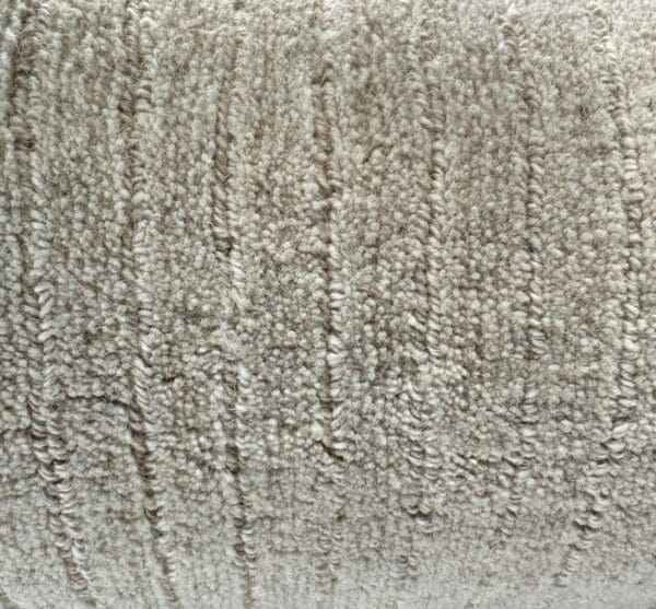 Close-up of a textured beige Man Made Luxurious Carpet Remnant with visible horizontal and vertical stitching patterns.
