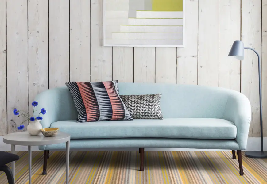 Light blue sofa with patterned cushions.