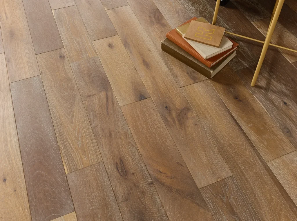 Wooden floor with stacked books and chair.