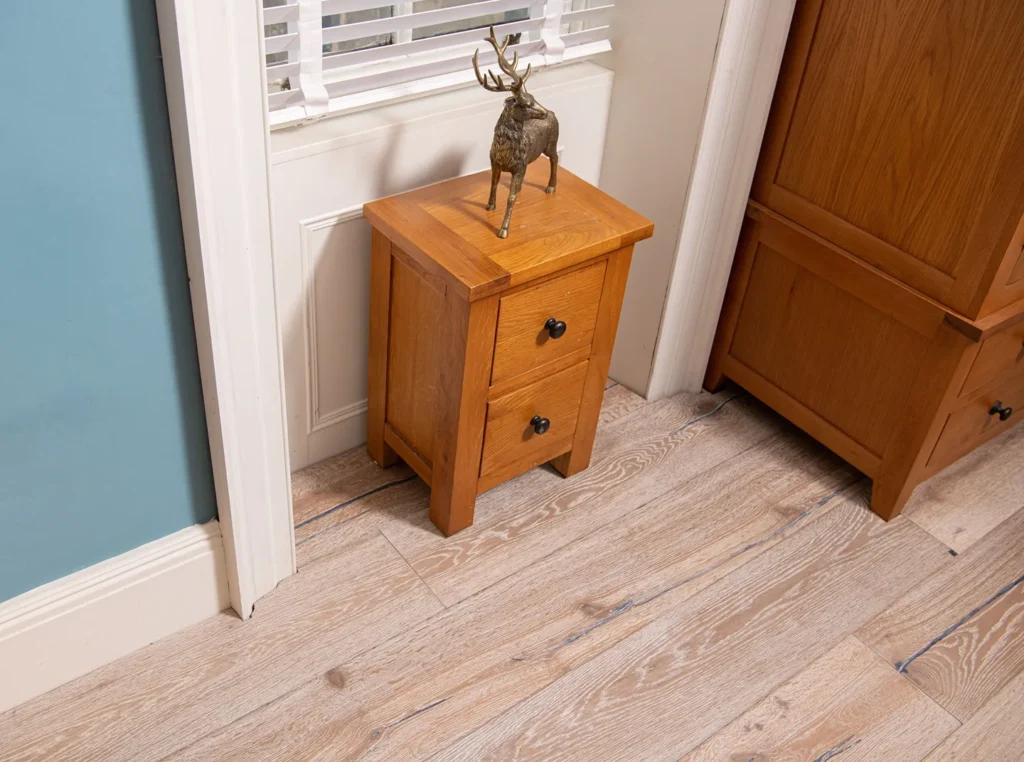 Wooden nightstand with reindeer figurine on top.