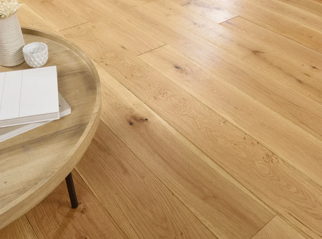 Light wood flooring with round wooden table.