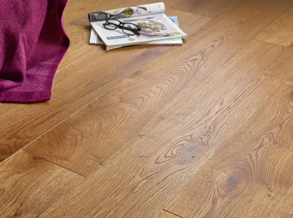 Wooden floor with magazines and glasses nearby.