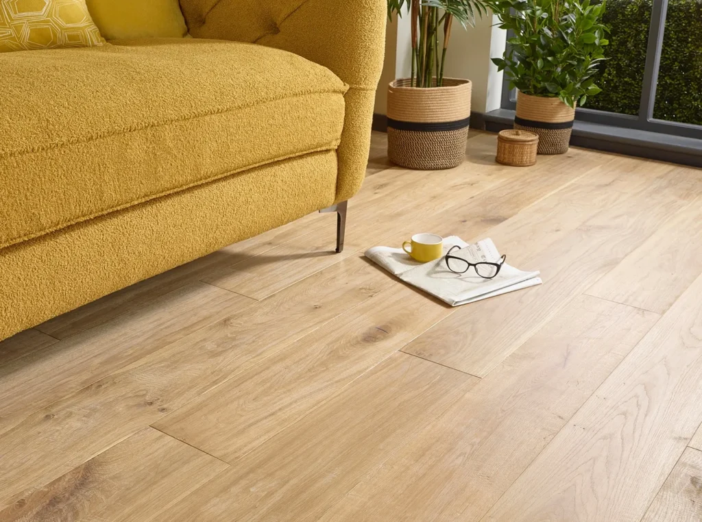 Yellow sofa, wooden floor, plants, and glasses.