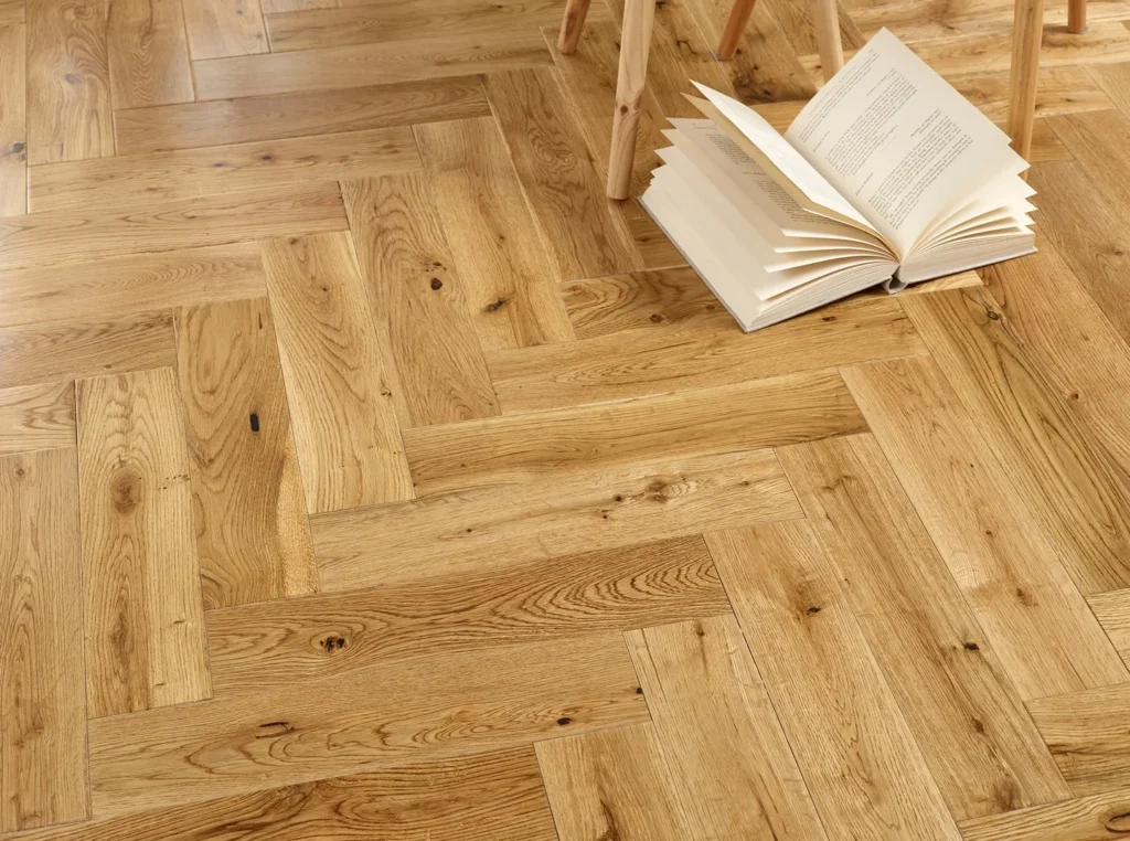 Open book on wooden herringbone floor.