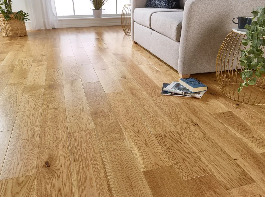 Wooden floor with sofa and books nearby.