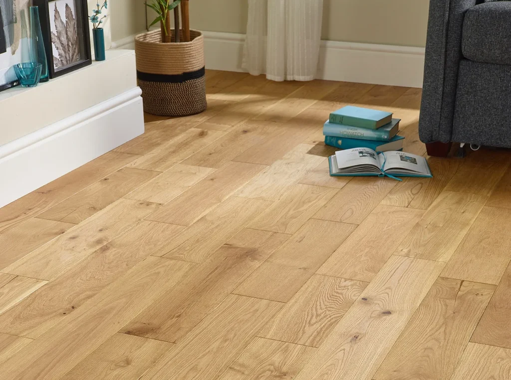 Wooden floor with books and sofa.