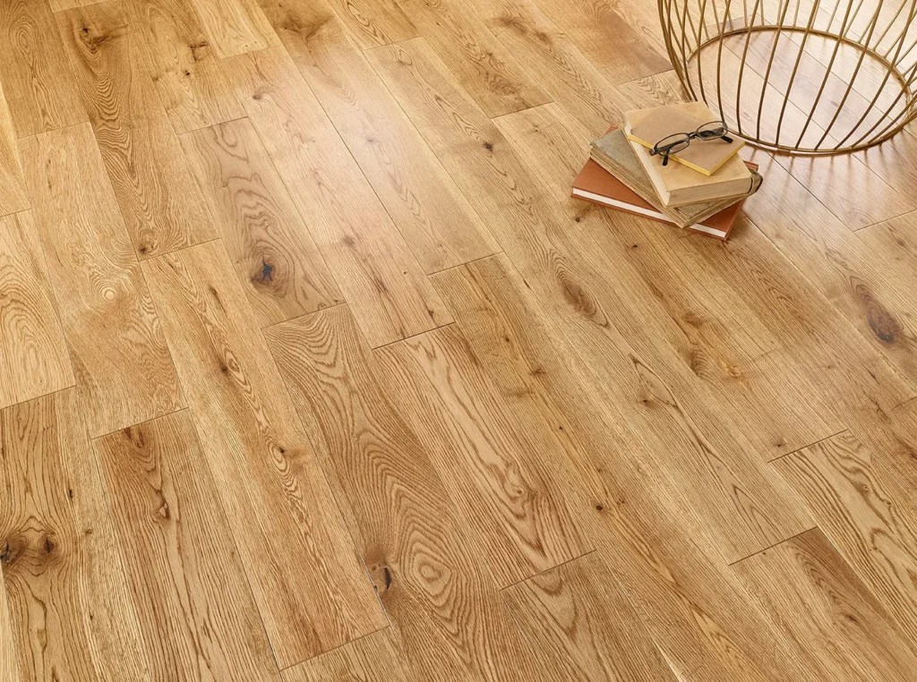 Wooden floor with books and metal basket.
