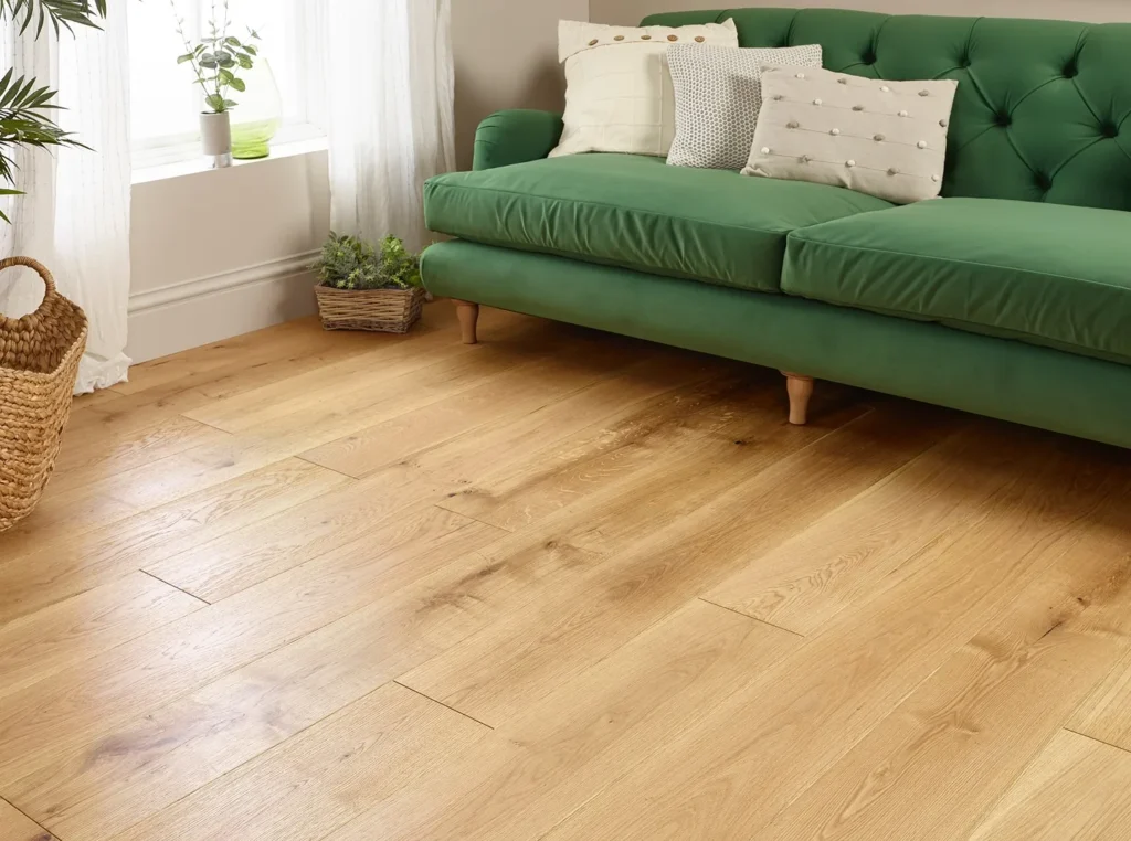 Green sofa on wooden floor near window.