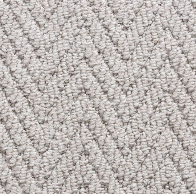 Beige herringbone pattern carpet texture close-up.