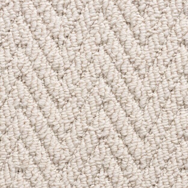 Beige herringbone textured carpet pattern close-up.