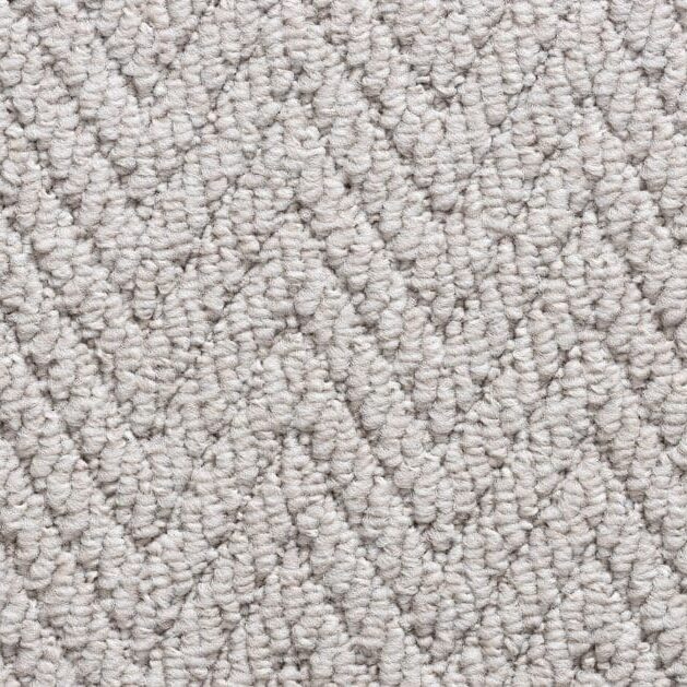 Beige herringbone pattern carpet texture close-up.