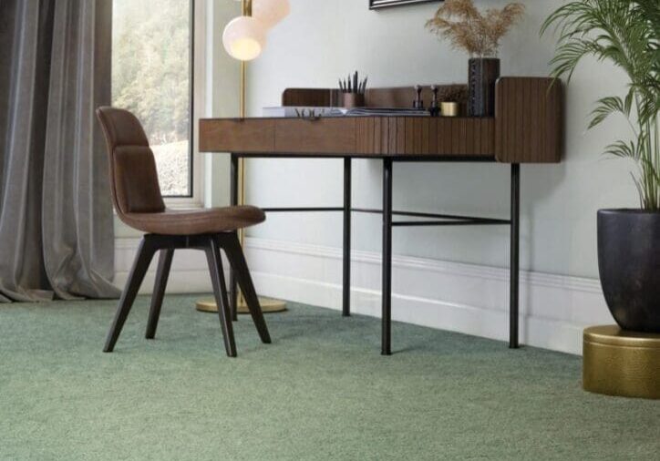 Modern workspace with green carpet and plants.
